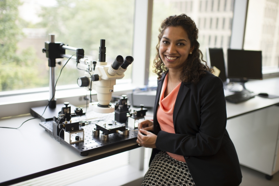 Dr. Saniya LeBlanc in front of microscope and other equipment